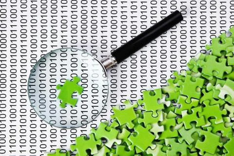 Puzzles and magnifying glass on a binary code Foto stock
