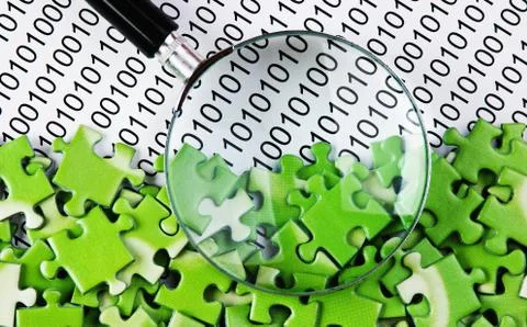 Puzzles and magnifying glass on a binary code 库存照片