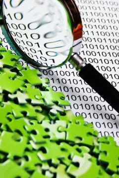 Puzzles and magnifying glass on a binary code Foto stock