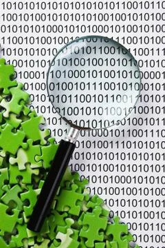 Puzzles and magnifying glass on a binary code Stockfoto's