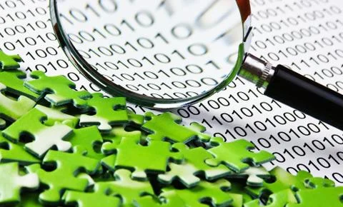 Puzzles and magnifying glass on a binary code 库存照片