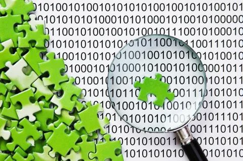 Puzzles and magnifying glass on a binary code 库存照片