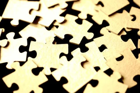 Puzzles scattered on a black surface close up. Abstract background Stock Photos