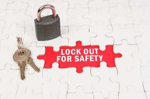 On puzzles there is a lock and keys, on a red surface there is an inscription Stock Photos