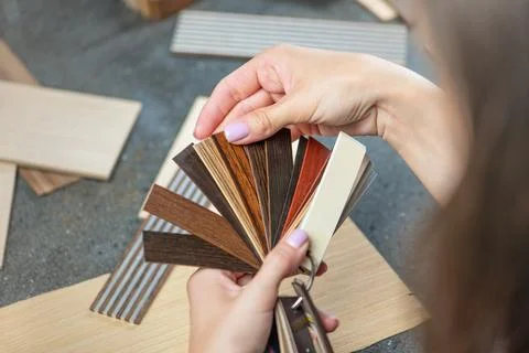 PVC edging samples close up. Women's hands hold samples of PVC edging in their Stock Photos