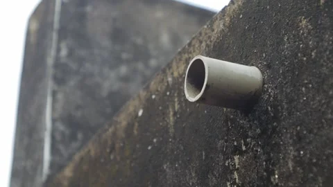PVC pipe protruding from dark mossy concrete wall Vidéo 337292000