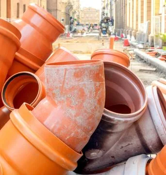 PVC sewer pipe joint plastic pipework orange road work surfacing Stock Photos