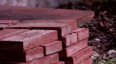 Pyle of thin red bricks stacked up in morning light Stock Footage 53311792