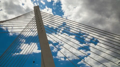 Pylon of a cable stayed bridge under fast moving white and gray clouds Stock Footage 135535161