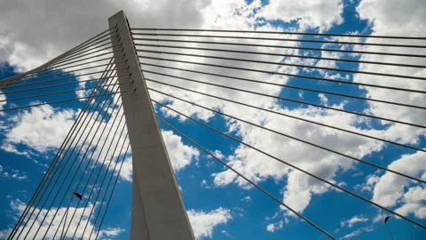 Pylon of a cable stayed bridge under fast moving white and gray clouds Stock Footage 135537762