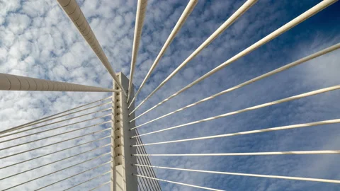 Pylon of a cable stayed bridge under fast moving white clouds in blue sky Stock Footage 145370538
