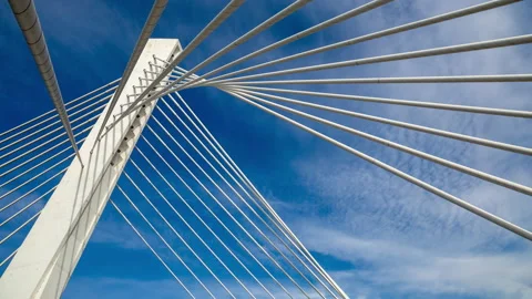 Pylon of a cable stayed bridge under fast moving white clouds in blue sky Stock Footage 145373152