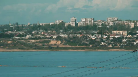 Pylons of the old electricity in fields and a lake with buildings on background Stock Footage 64992446