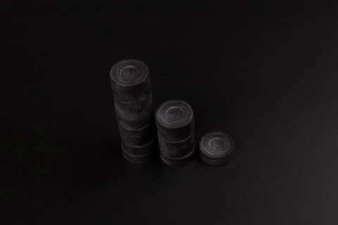 Pyramid of black chips backgammon for playing backgammon on black background. 写真素材
