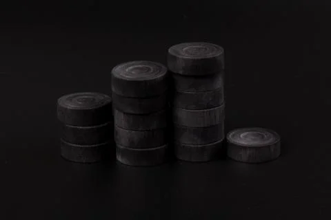 Pyramid of black chips backgammon for playing backgammon on black background. Stock Photos