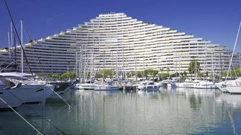 Pyramid building overlooking a marina filled with sailboats on a sunny day. Vídeos de archivo 339258527
