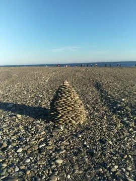 The pyramid is composed of pebbles of the beach on the seafront Stock Photos
