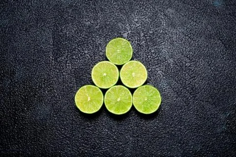 Pyramid of cut limes on blacks background Stock Photos