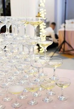 Pyramid of empty and filled with champagne glasses against the backdrop of .. Stock Photos