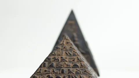 Pyramid figurine on a white background. the pyramid is spinning Stock Footage 129411065