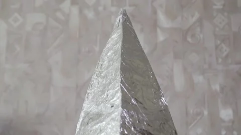 A pyramid made of foil is dressed on a human head, back view Vídeo Stock 141121189