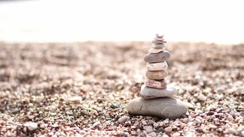 Pyramid of multi-colored stones stands on a pebble beach by the sea Stock Footage 275556759