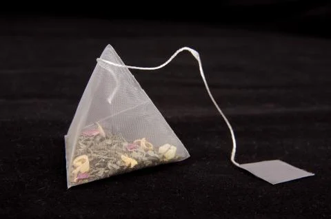 Pyramid shape teabag on the dark background Stock Photos