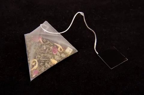 Pyramid shape teabag on the dark background 写真素材