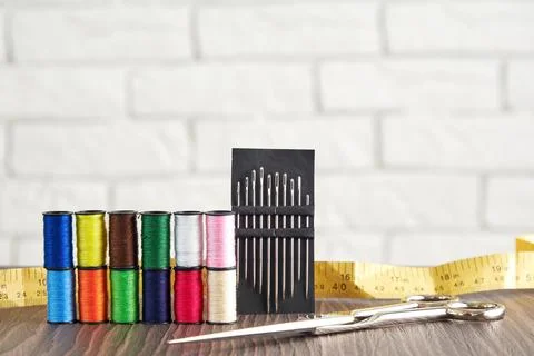 Pyramid of spools of colorful sewing threads and needles, measuring, scissors Stock Photos