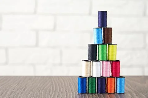 Pyramid of spools of multi-colored sewing threads on the table Stock Photos