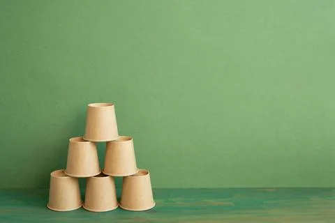 Pyramid stack of brown cup on wooden table. green background. business dev... Stockfoto's