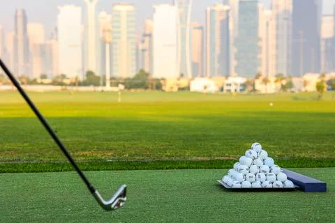 A pyramid stack of golf balls on a green turf with Stock Photos