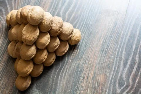 Pyramid of walnuts. Closeup view from top. Walnuts are on the wooden surface. Stock Photos