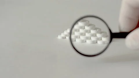 Pyramid of white tablets viewed through a magnifier 4K Video stock 116911205