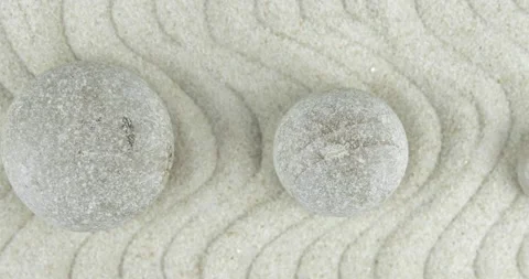 Pyramids of white and gray zen stones on sand with abstract wave drawings Stock Footage 152889574