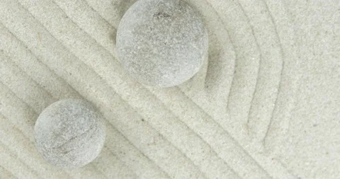 Pyramids of white and gray zen stones on sand with abstract wave drawings Stock Footage 152889577