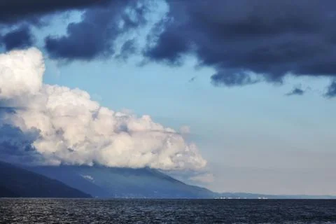 Pyrocumulative and thunderclouds over the mountains and the sea Stock Photos