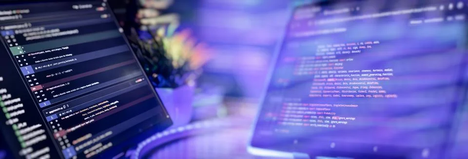 Python programming on dual monitors in tech workspace Stock Photos