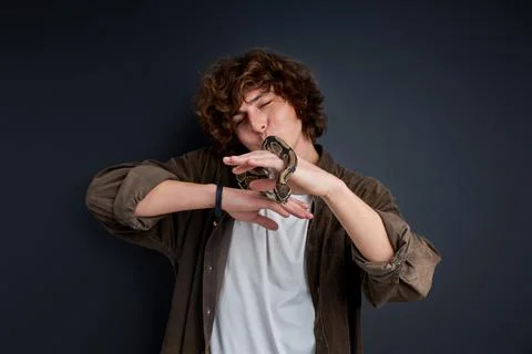 Python snake coiling around mans hand Foto stock