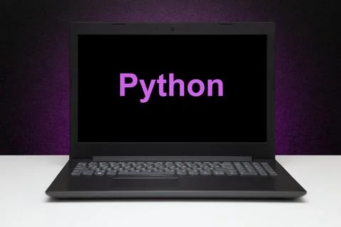 Python text on laptop screen on textured black background with purple light. 库存照片