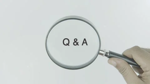 Q and A text or word highlighted by a magnifying glass in a hand on a white Stock Footage 303696811