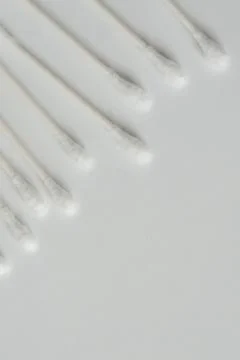 Q-tip, or cotton bud swab top view on vertical white background with blank em Stock Photos