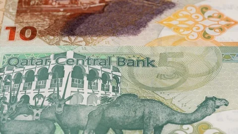 Qatar riyal notes fast tracking. Qatari currency. Slider shot, low angle. 4K Stock Footage 125994513