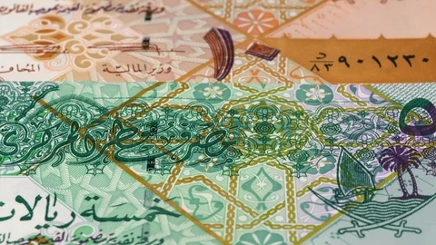 Qatar riyal notes fast tracking. Qatari money. Slider shot, low angle. 4K Stock Footage 125995963