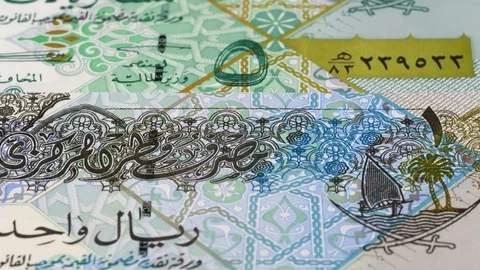 Qatar riyal notes slow tracking. Qatari money. Slider shot, low angle. 4K Stock Footage 125995796