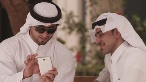 Qatari men with mobile phone sitting on bench. Stock Footage 90817341