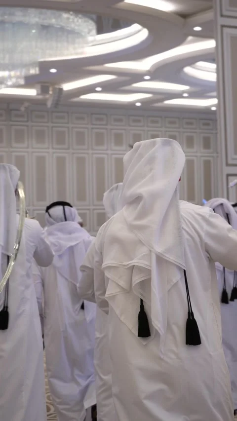 Qatari men in traditional white thobes perform the Ardah sword dance at a grand Stock Footage 341142760