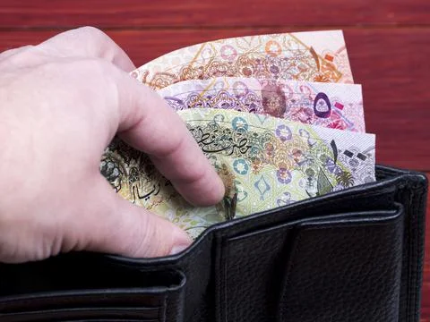 Qatari money in the black wallet. Stock Photos