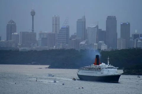 QE2 with cityscape background leaving Sydney Harbour Stock Photos