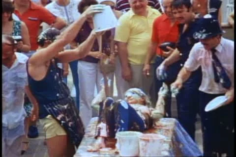 QE2 Court of King Neptune, 1982 World Cruise, pour syrup, in chair, dunk pool Stock Footage